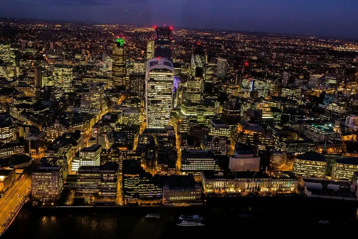 A stunning aerial view capturing London's illuminated skyline at night.