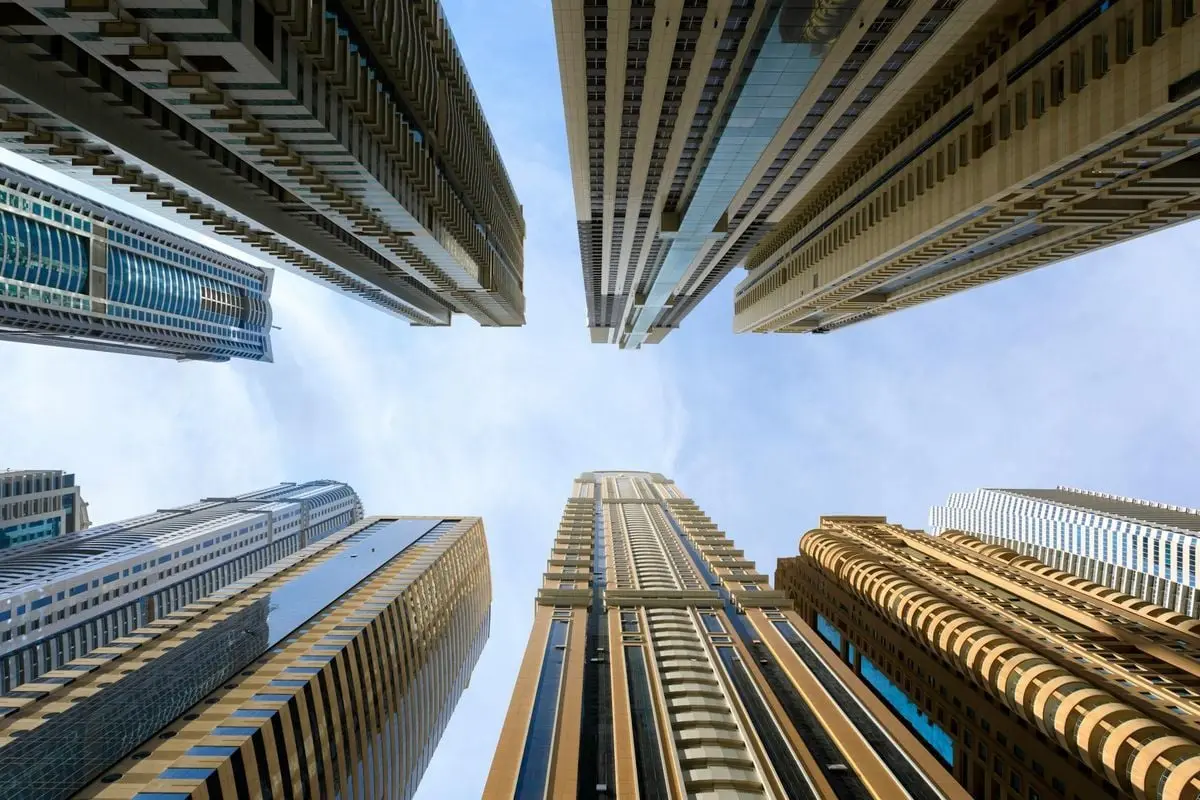 Low angle view of modern skyscrapers against a bright sky, showcasing urban architecture.