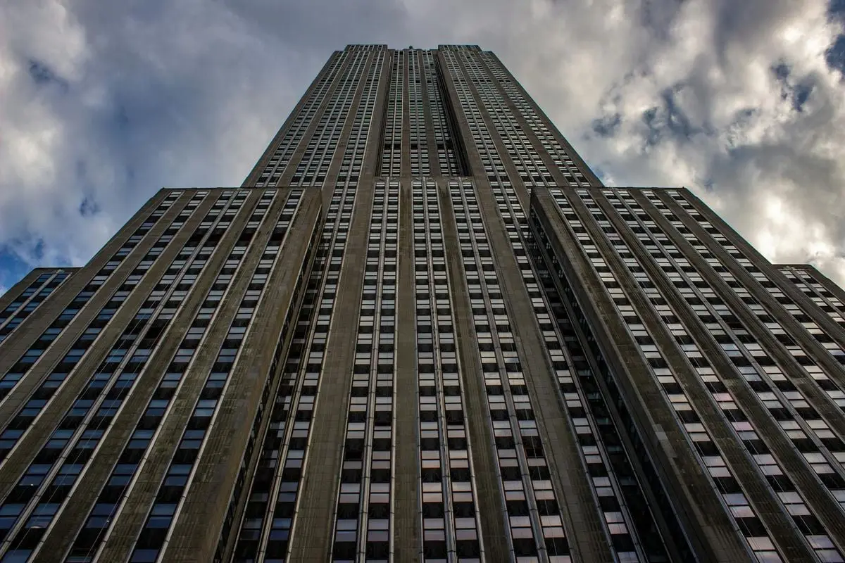 Stunning upward view of the Empire State Building against a cloudy sky in New York City.