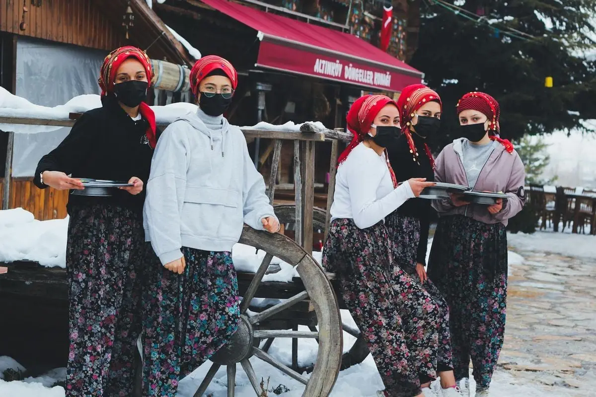 Group of Turkish women wearing masks and traditional attire during winter in Türkiye.