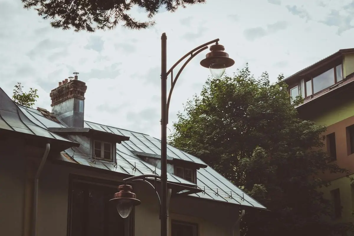 A cozy urban scene featuring a classic street lamp and traditional rooftops in Brașov, Romania.