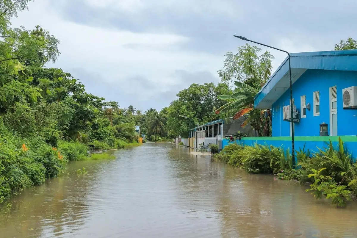 A tropical street in Nolhivaranfaru, Maldives, submerged due to flooding.