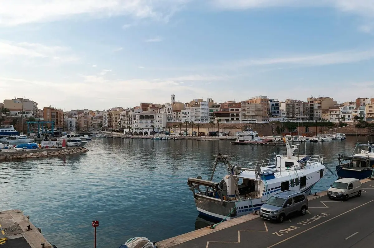 Beautiful harbor view in L'Ametlla de Mar, Spain, showcasing moored boats and coastal town scenery.