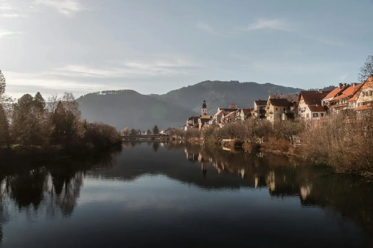 Tranquil morning view of Frohnleiten, Austria with reflections on the Mur River.