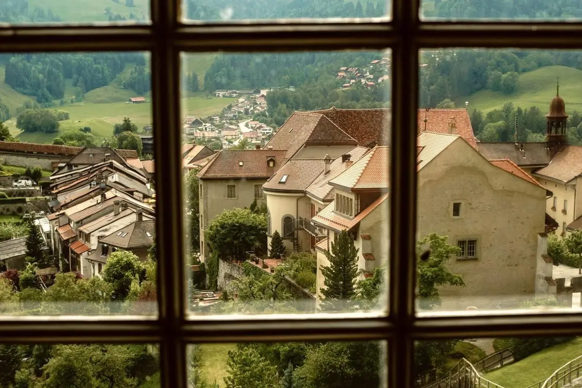 Picturesque view of a quaint European village through a vintage window frame.