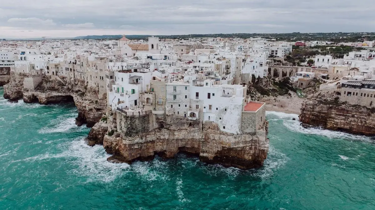 Explore the stunning cliffside architecture of Polignano a Mare in southern Italy overlooking the turquoise sea.