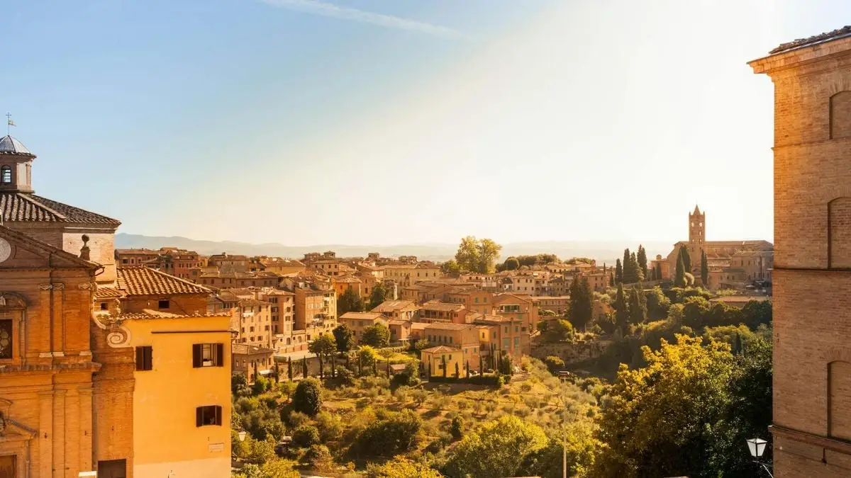 Beautiful panoramic view of a charming historic Italian town bathed in warm sunset light.