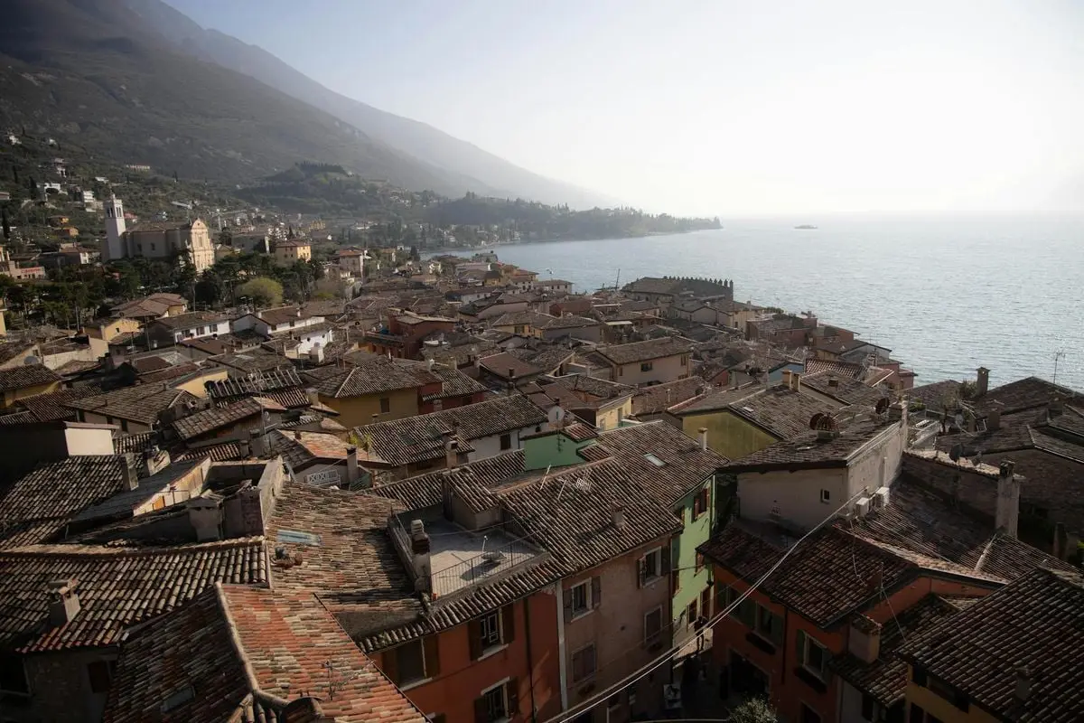A captivating aerial view of Malcesine, Italy showcasing roofs and Lake Garda.