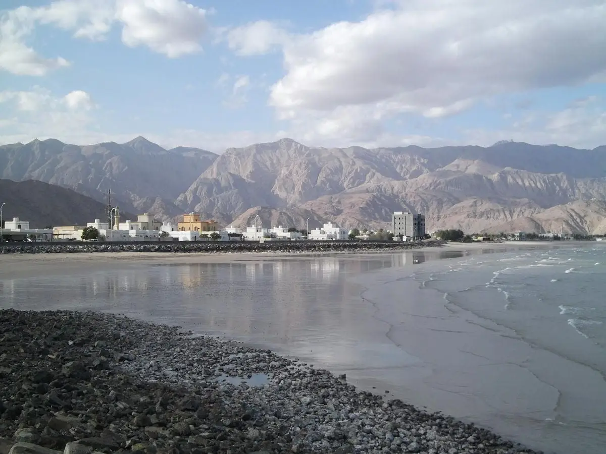 Charming coastal town set against a backdrop of majestic mountains and a calm sea.