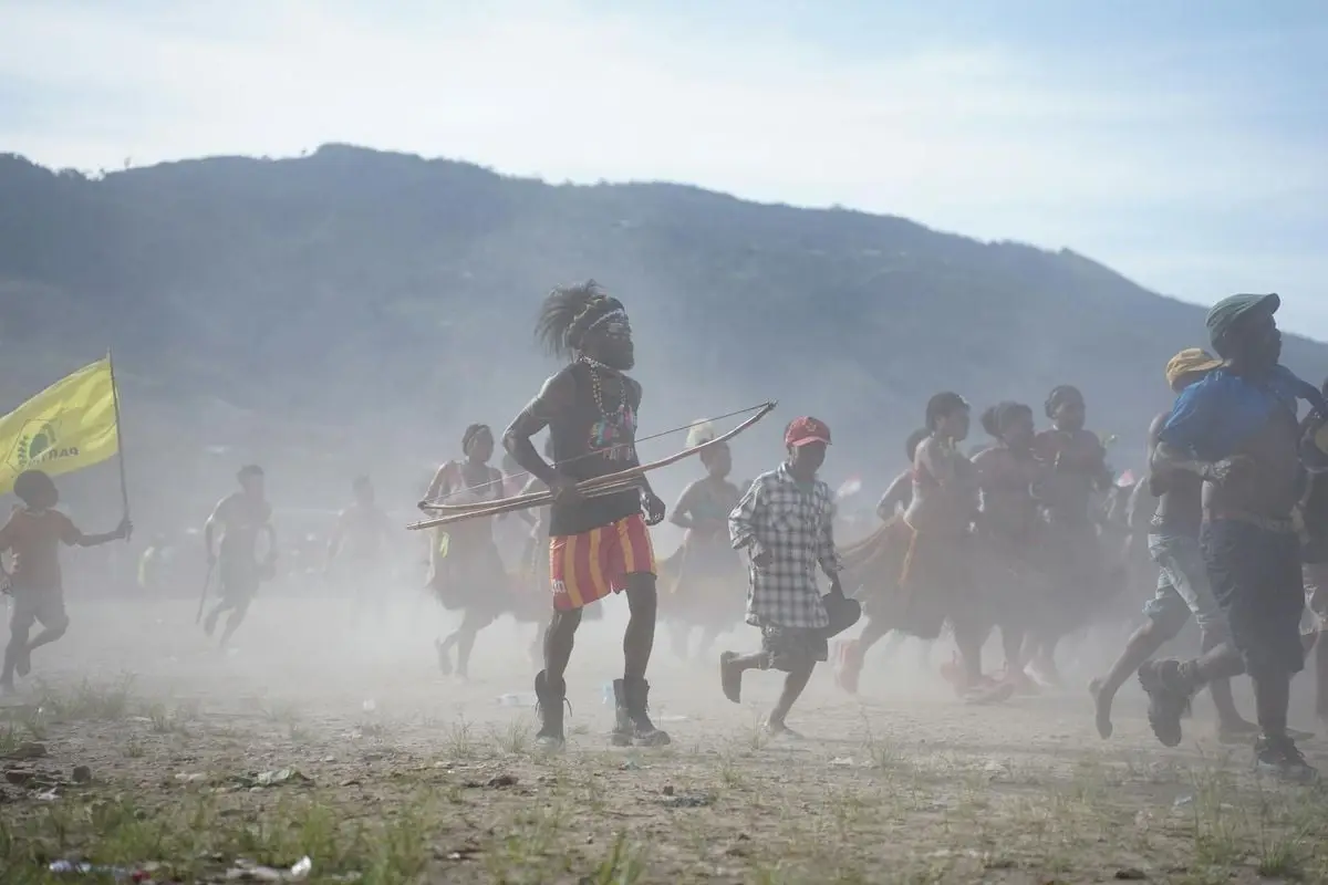 Energetic participants dancing and celebrating at a cultural festival in Papua, Indonesia.