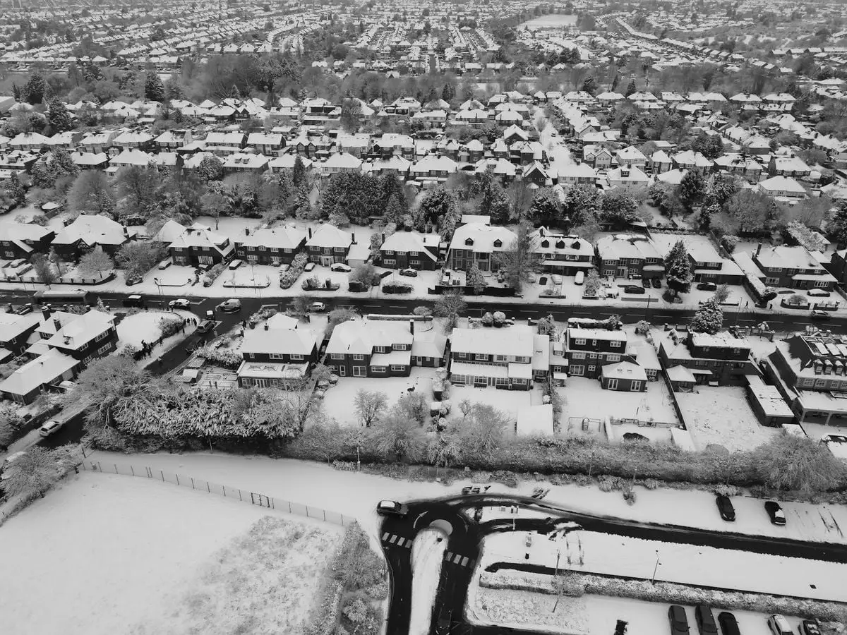 A breathtaking aerial view of a snow-covered residential area in Luton, England during winter.