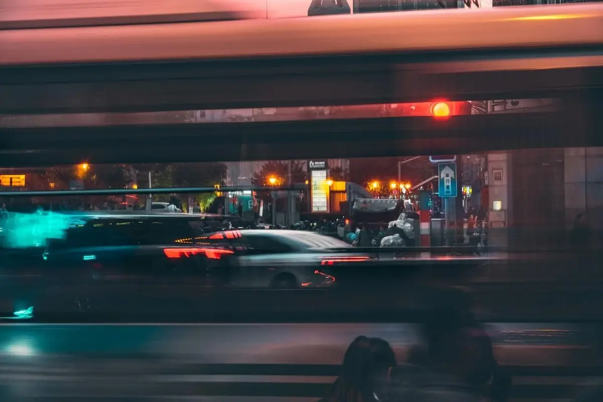Long exposure capturing vibrant city lights and motion blur on a bustling night street.