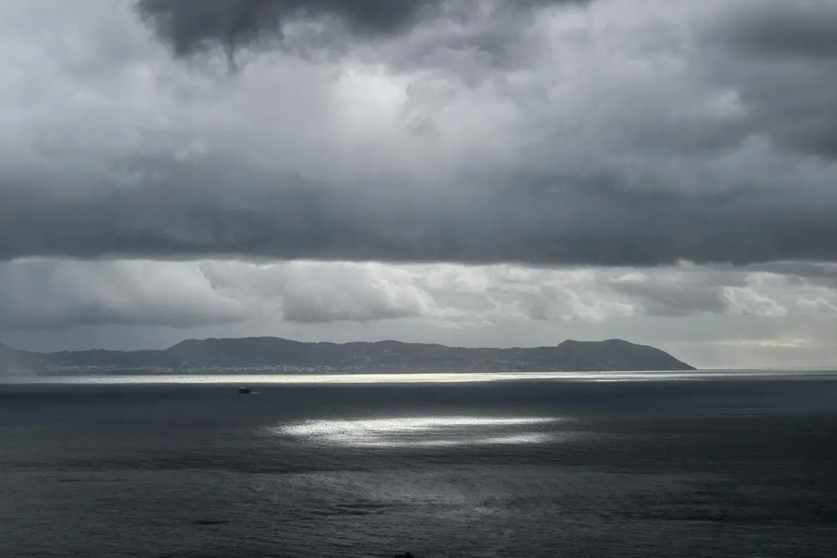 Spectacular view of dramatic clouds over the Gulf of Naples, highlighting the coast under a moody sky.