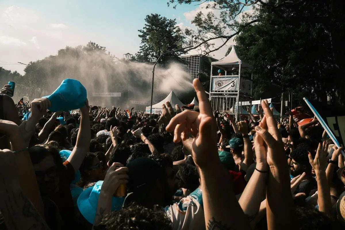 Vibrant crowd enjoying an outdoor music festival on a sunny day.
