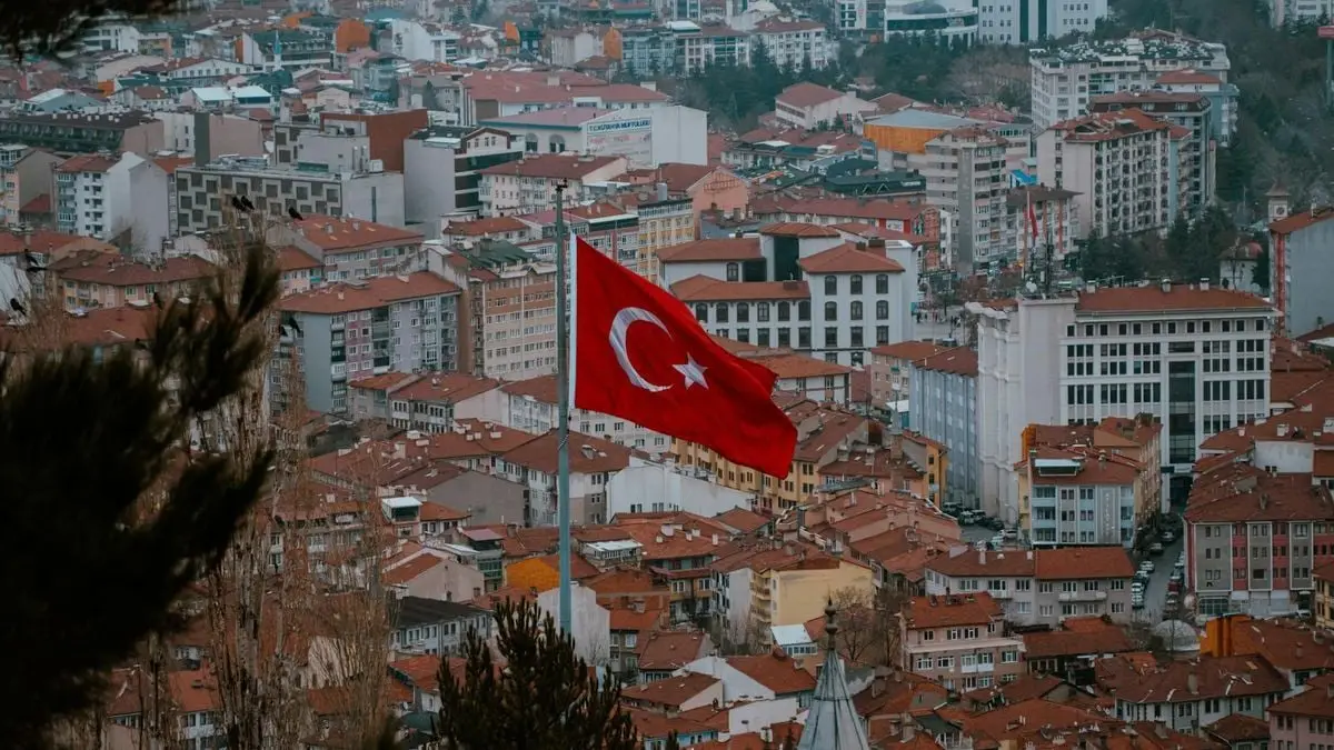 Aerial view of Afyonkarahisar city with the Turkish flag prominently displayed.