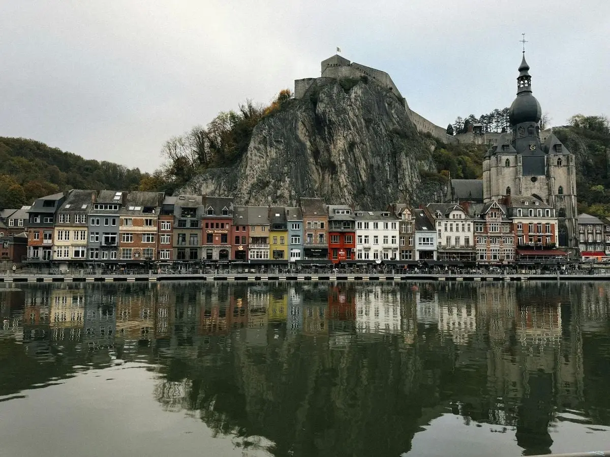 Colorful houses and church along the Meuse River in Dinant, Wallonia, Belgium.