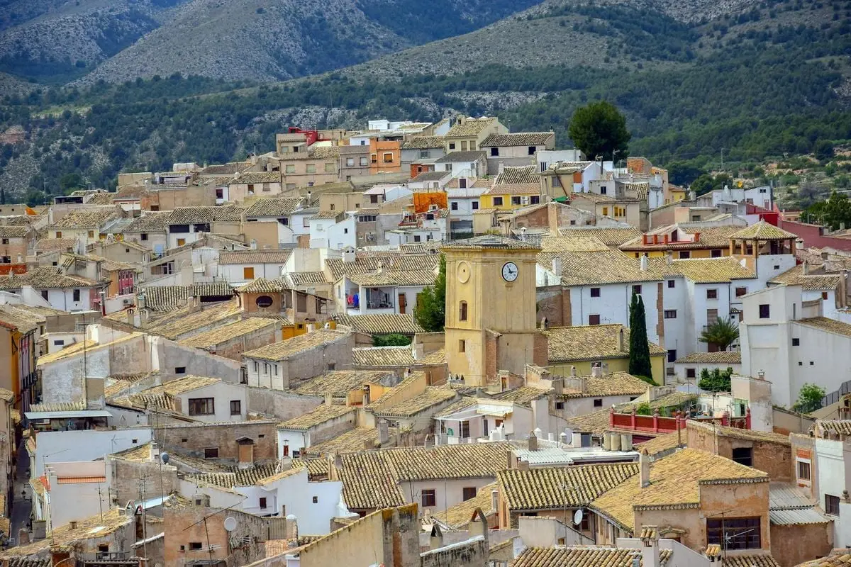 Charming aerial cityscape of Caravaca de la Cruz with rustic buildings and scenic mountains.