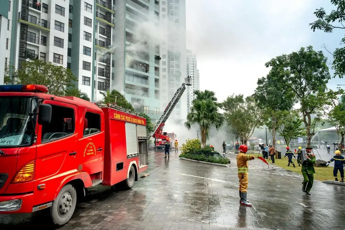 Firefighting operation at a high-rise apartment building, firefighters and trucks in action.