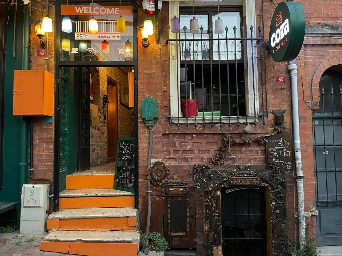 Inviting entrance to a café with eclectic storefront, vibrant decor, and cozy ambiance.