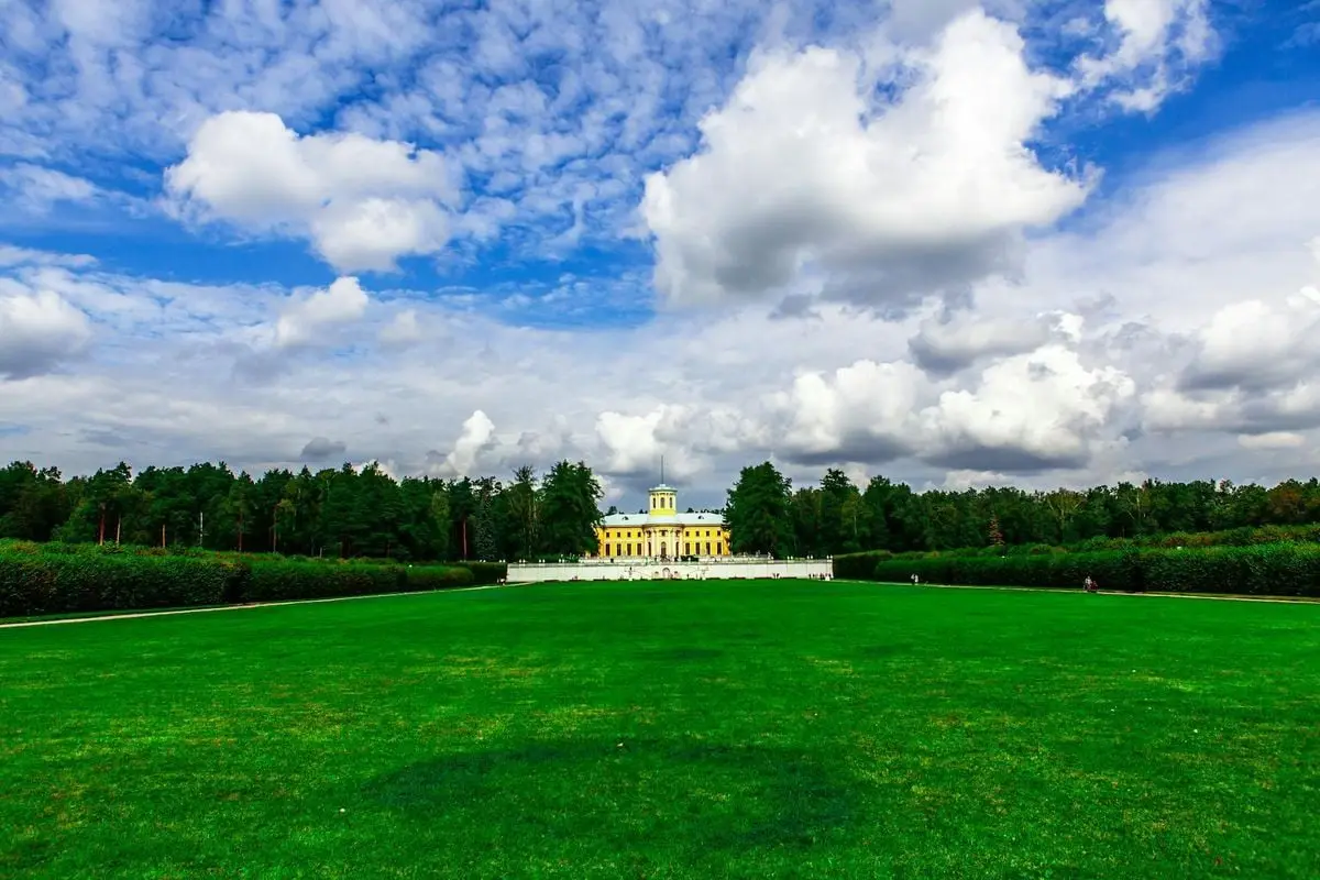 Explore the stunning Arkhangelskoye estate with its lush green lawn and dramatic cloudscape.