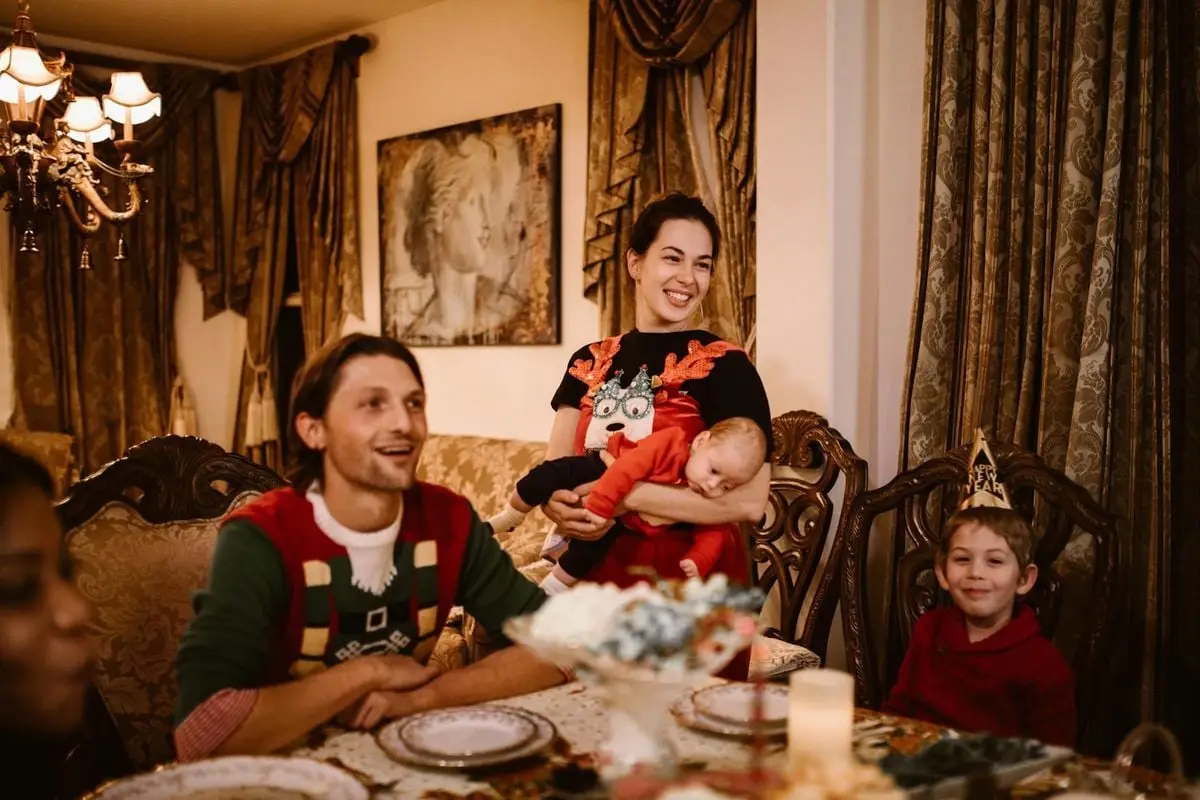 Family gathered indoors for a joyful holiday celebration with festive decorations.