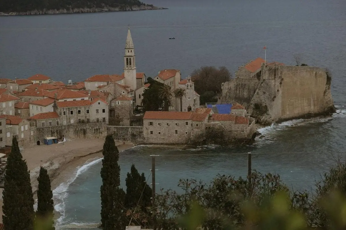 Historic Budva Old Town and coastline captured from above, featuring iconic medieval architecture.
