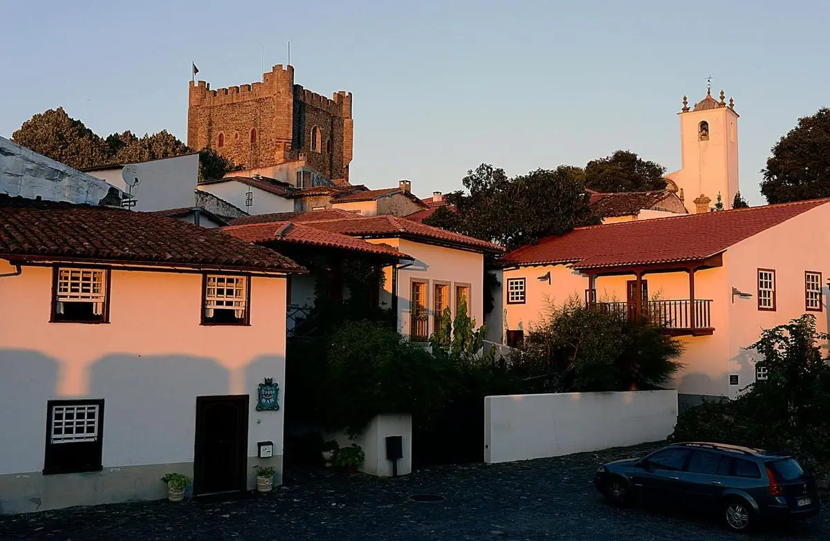 Scenic view of Bragança Castle and traditional houses at sunset, highlighting Portuguese architecture.