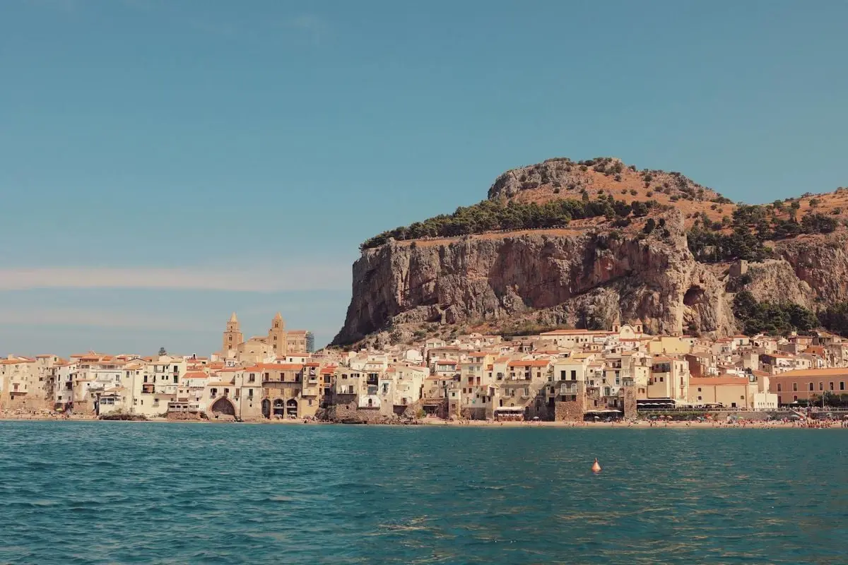 Explore the stunning seaside architecture of Cefalù, Sicily, with rocky backdrops and historic charm.