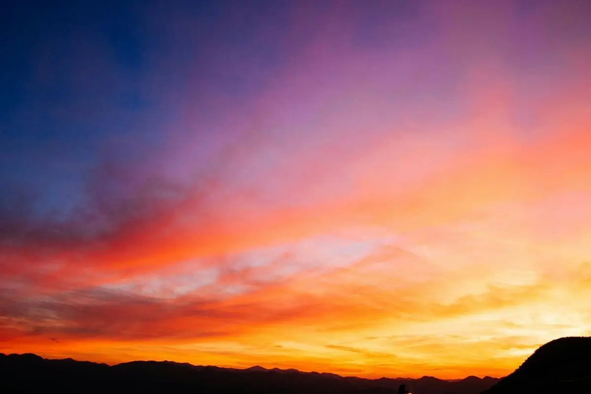 Beautiful colorful sunset sky with vibrant hues over mountain silhouettes.