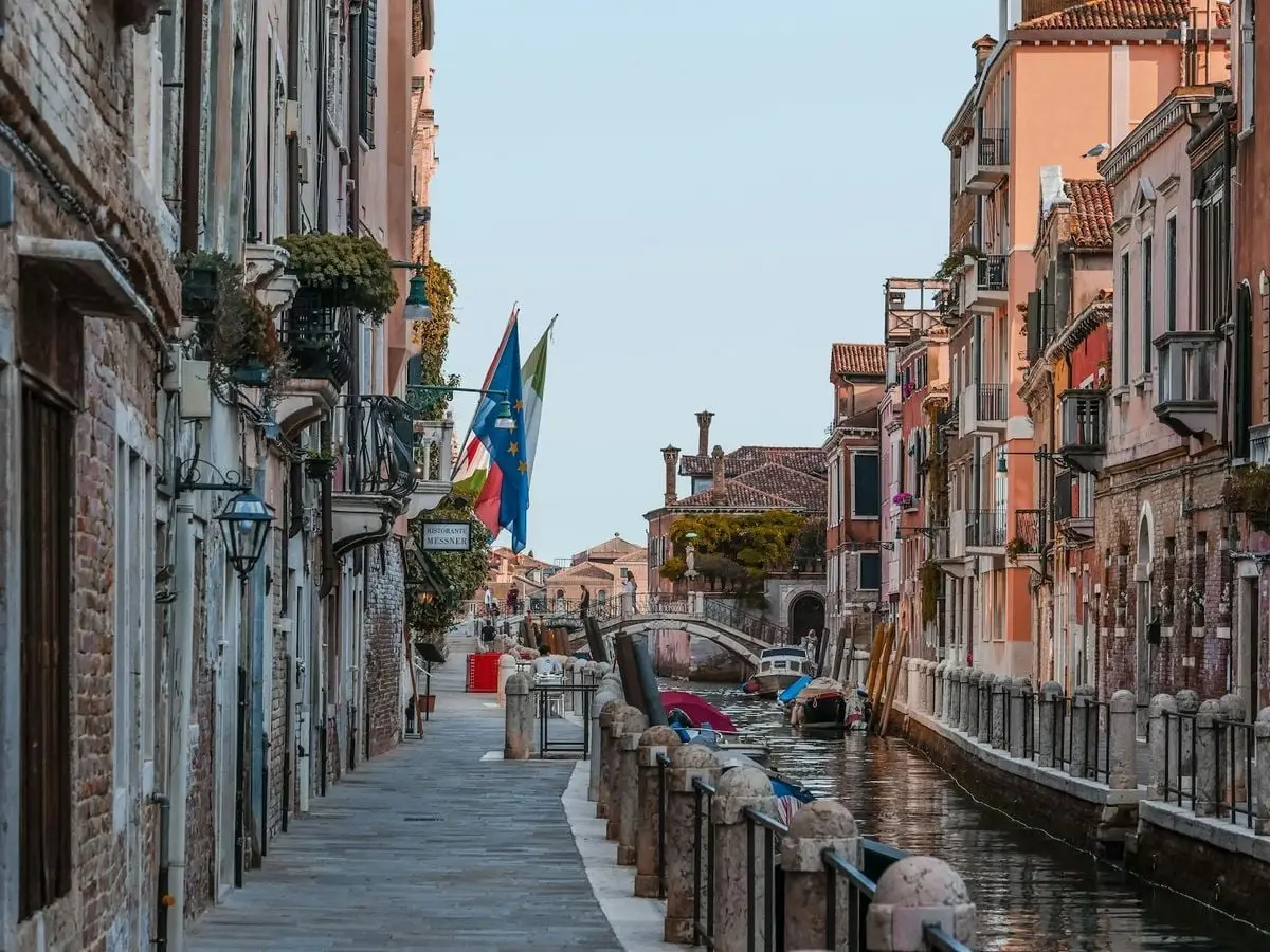 Beautiful view of a canal in Venice with colorful buildings and flags. Perfect travel destination.