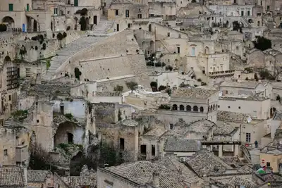 Explore the ancient stone buildings and winding stairways of Matera, Italy's historic cityscape.