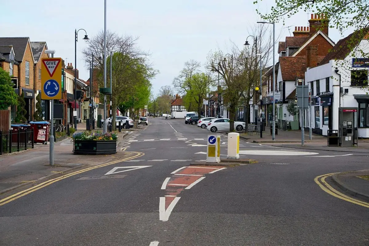 A quiet street scene in England featuring road signs and parked cars, a typical town view.