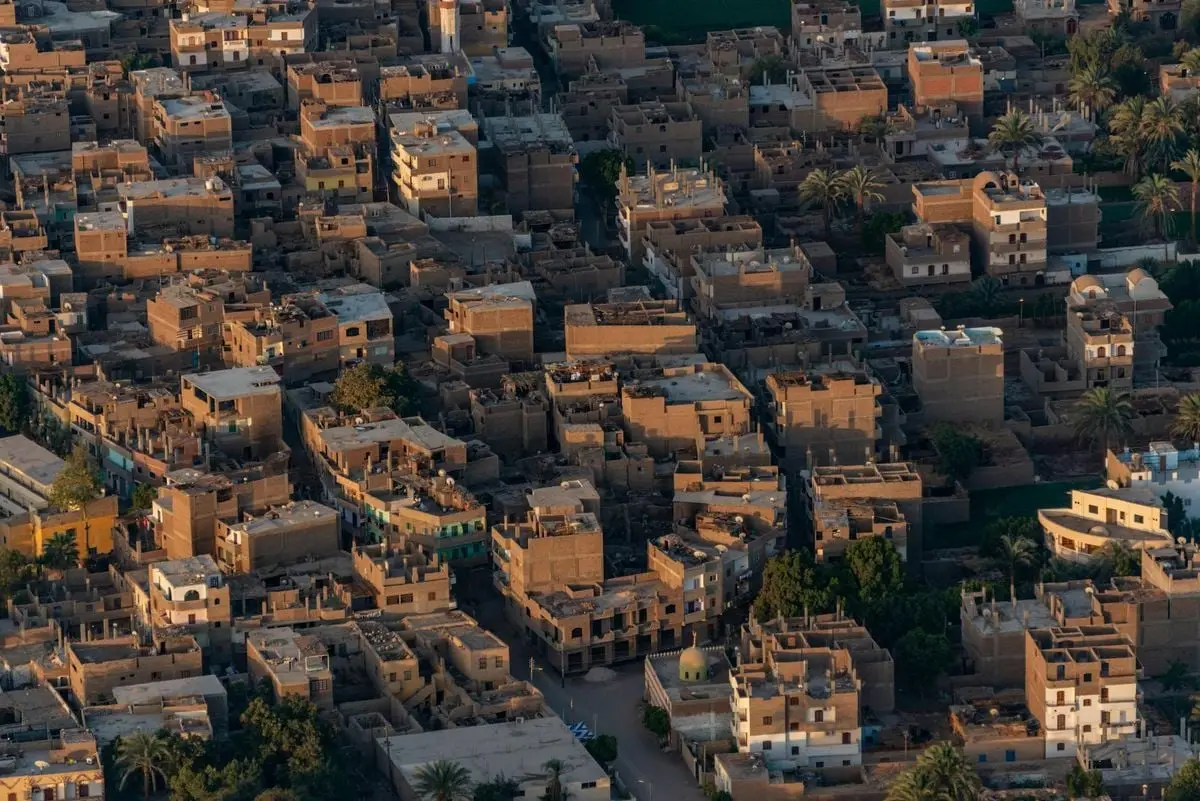 Discover the unique architecture of a desert town with traditional clay buildings from an aerial perspective.