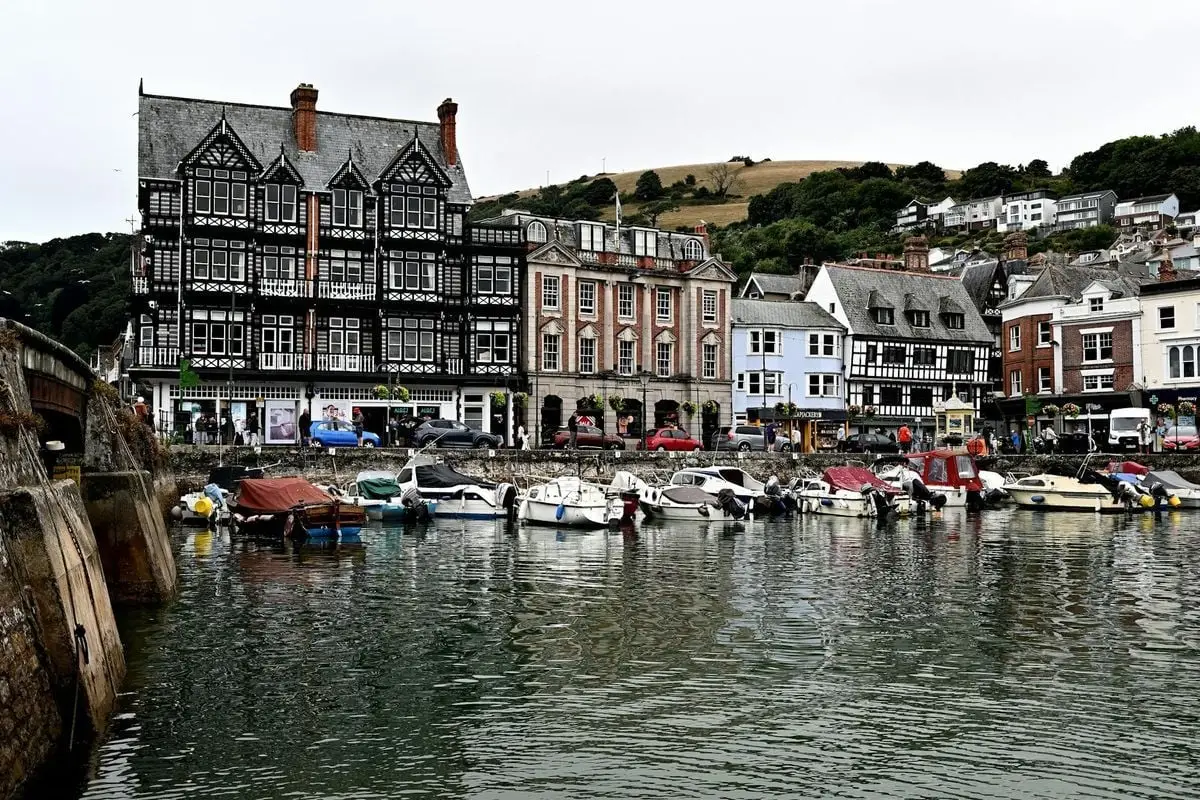 Picturesque view of Dartmouth Harbour with boats and historic buildings reflecting in the water.