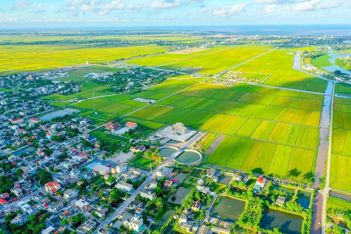 Scenic aerial view of a rural town with sprawling fields and lush greenery.