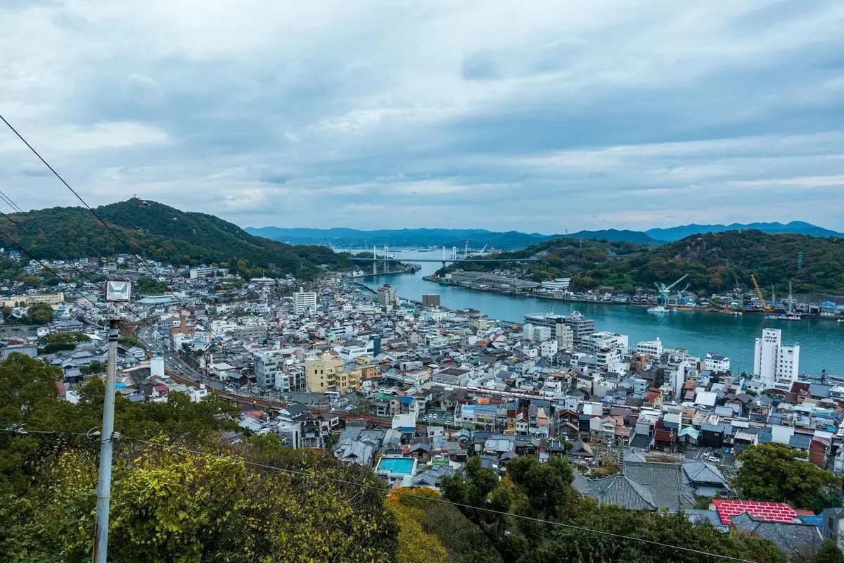 A stunning aerial view showcasing Onomichi cityscape with river and hills in Hiroshima, Japan.