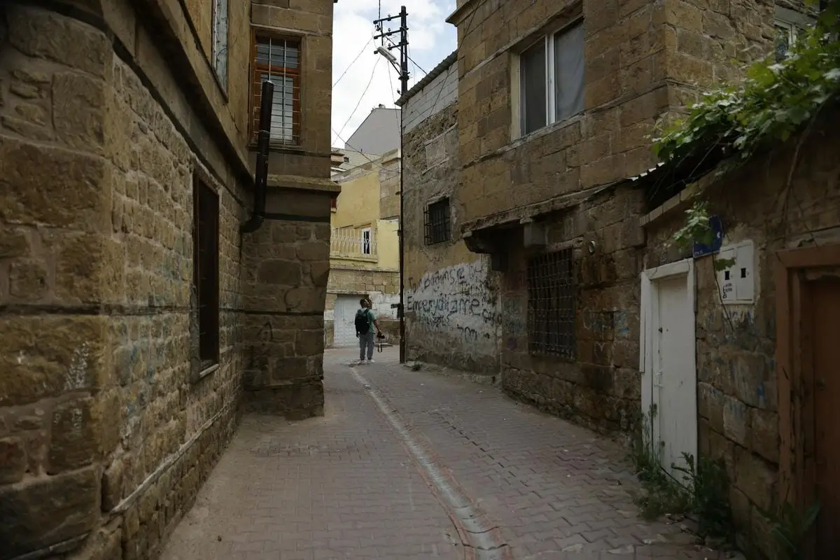Explore a narrow, historic alleyway in Niğde, Türkiye, capturing the charm of aged stone buildings.