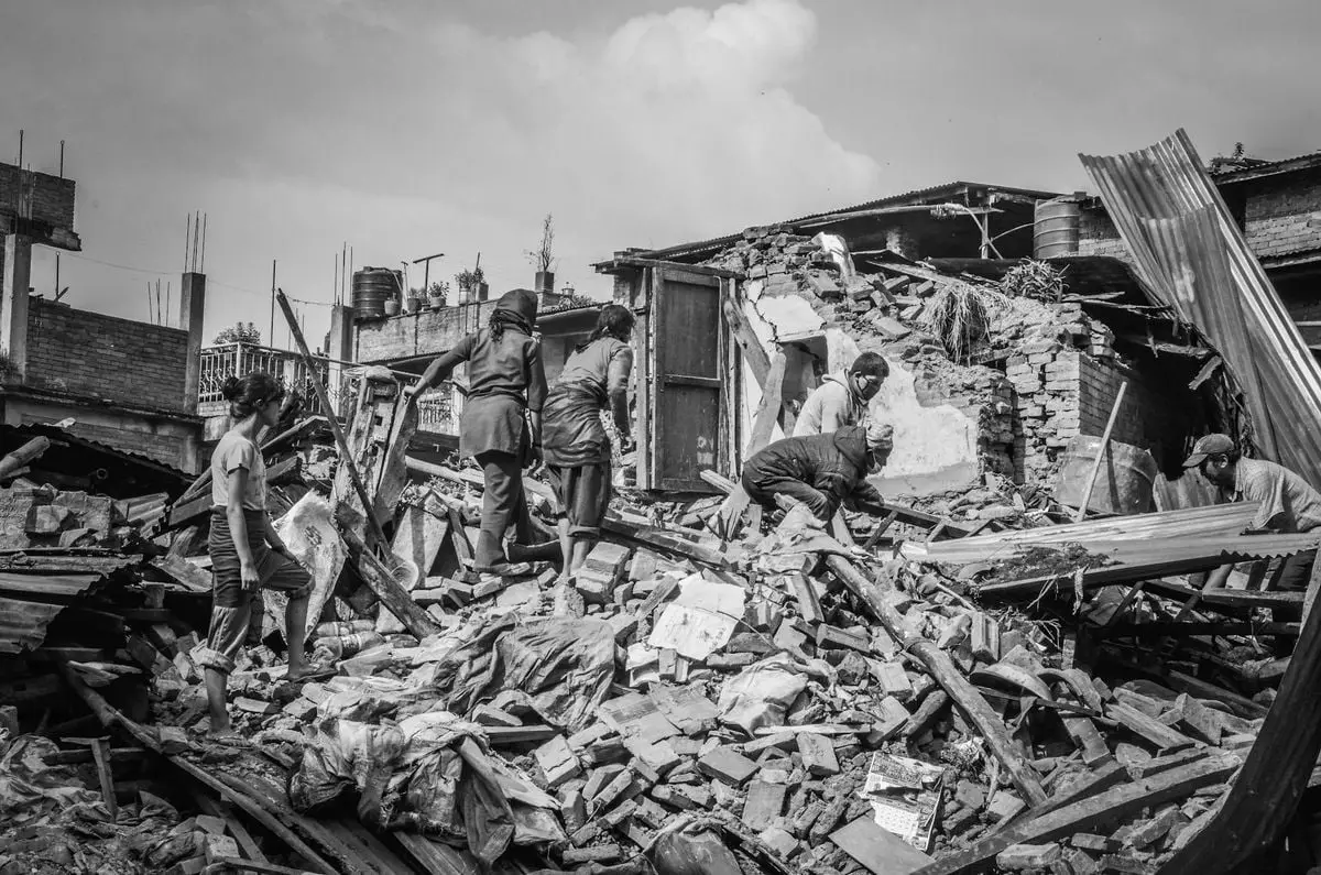 Black and white image of people amidst earthquake ruins in Bhaktapur, Nepal.