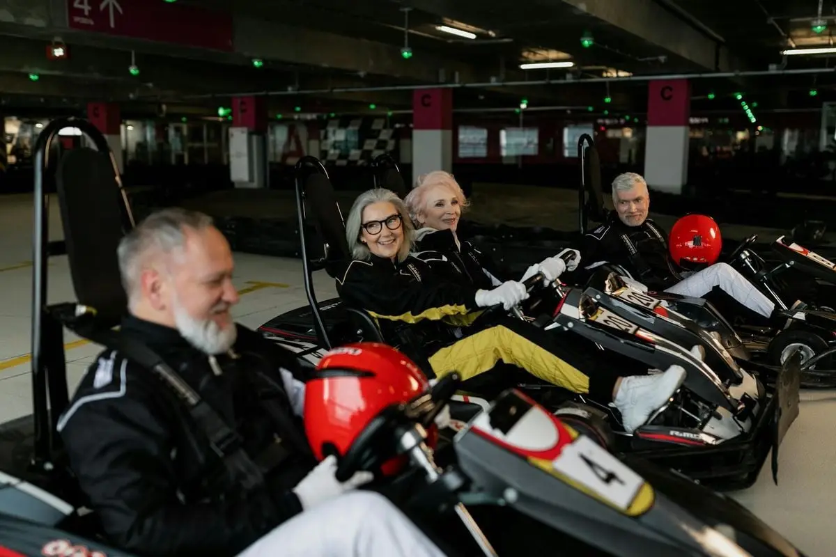 Senior adults having fun and embracing adventure in indoor go-kart racing.