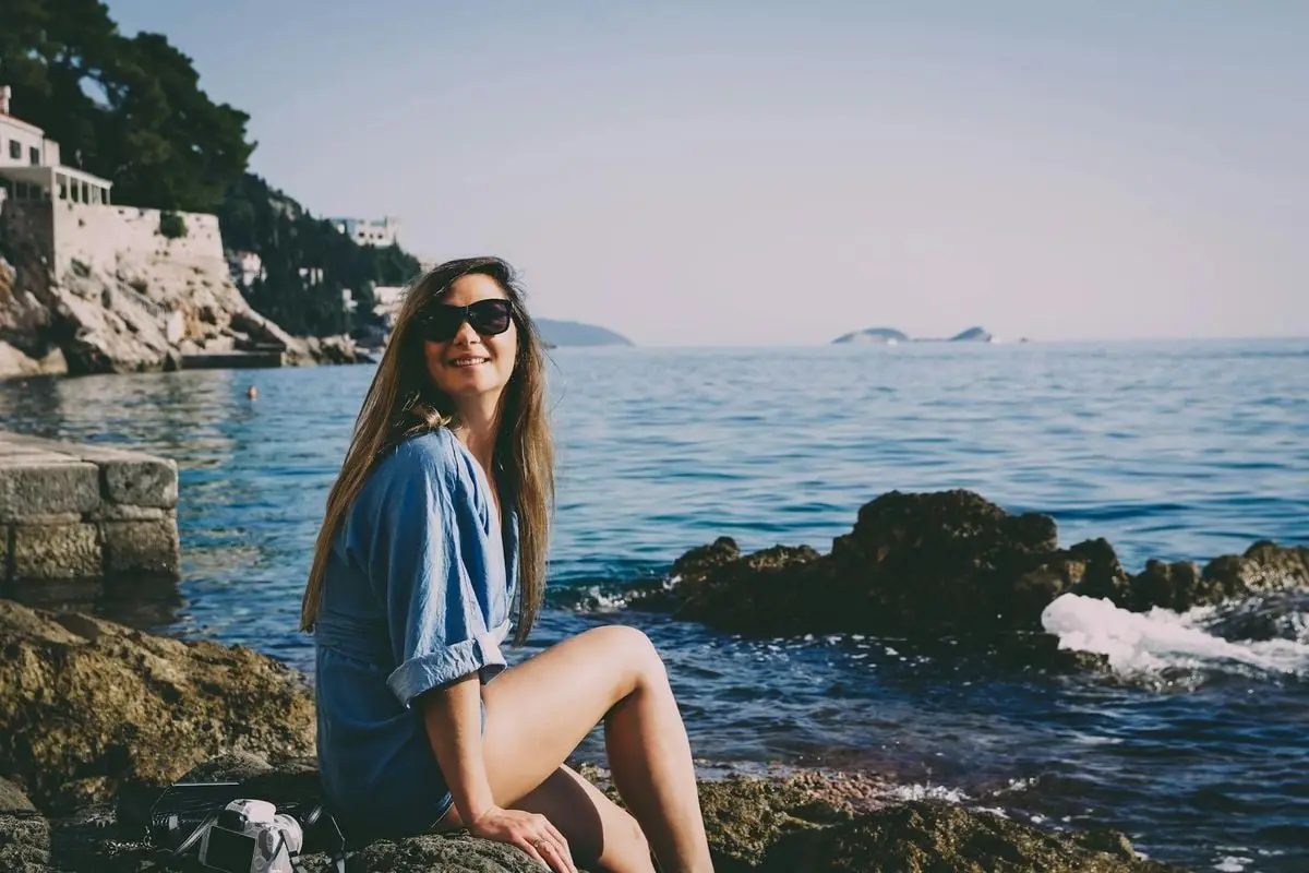 Young woman enjoying a sunny day by the Adriatic Sea in Dubrovnik, Croatia.