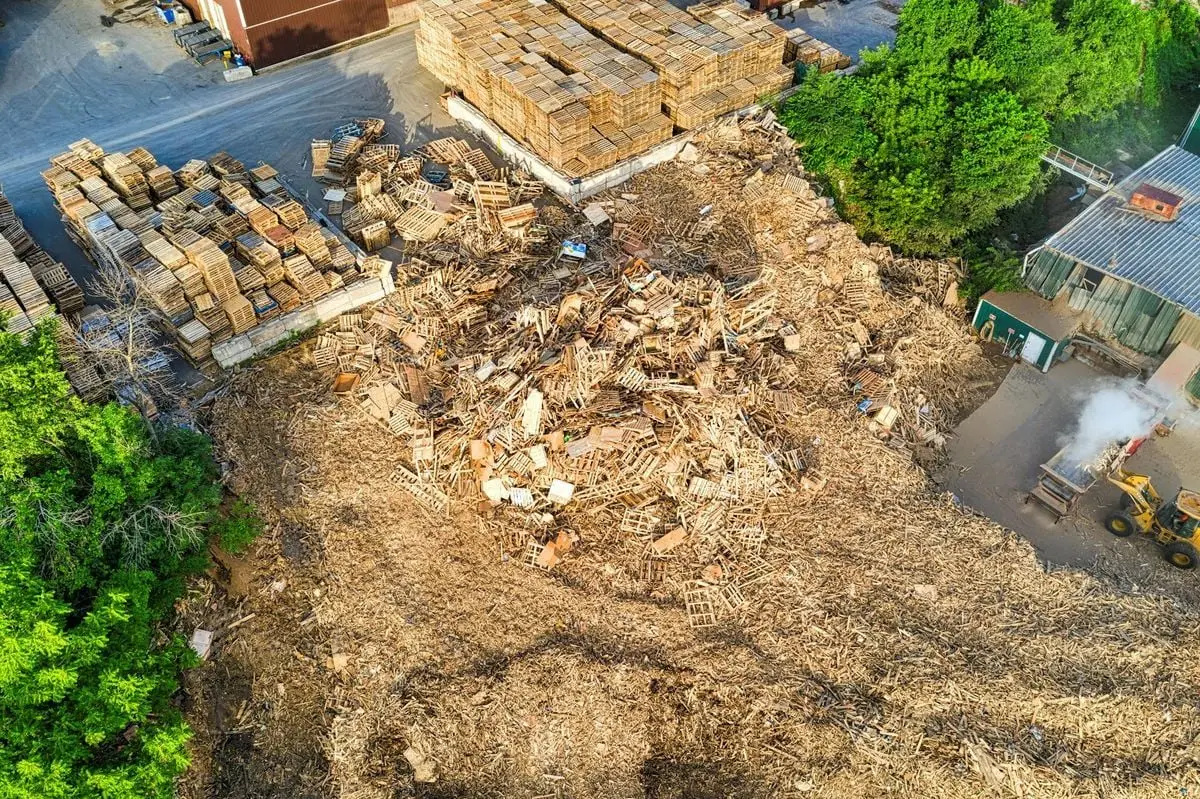 Aerial view of stacked wood pallets and waste in an industrial yard in Lake City, MN, USA.