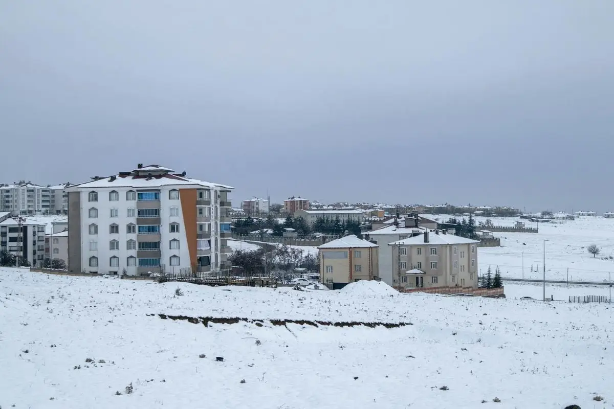 A scenic snowy winter landscape capturing residential buildings in Palu, Elazığ, Türkiye.