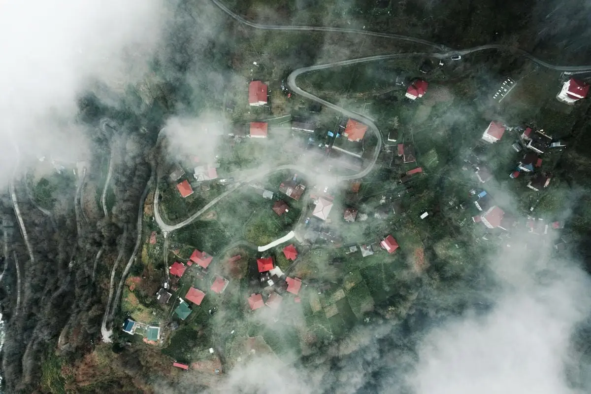 Drone shot capturing the fog-covered rural village of Arhavi, Türkiye from above.