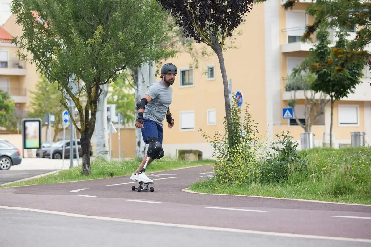 A man skateboards down a path in a Portuguese city, showcasing urban recreation and lifestyle.