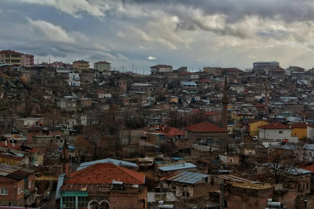 Scenic aerial view of a densely packed hillside town under a cloudy sky.