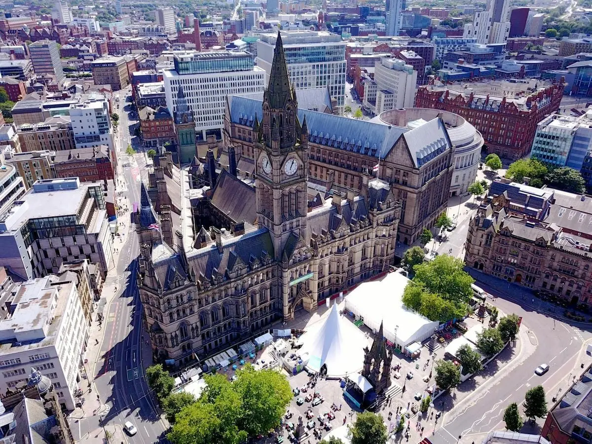 Aerial view of the iconic Manchester Town Hall and surrounding cityscape in the United Kingdom.