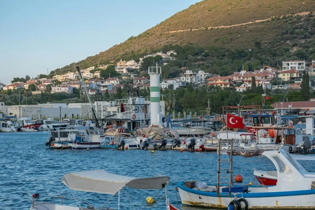 Charming Yenifoca marina with boats and hilly landscape, İzmir, Türkiye.