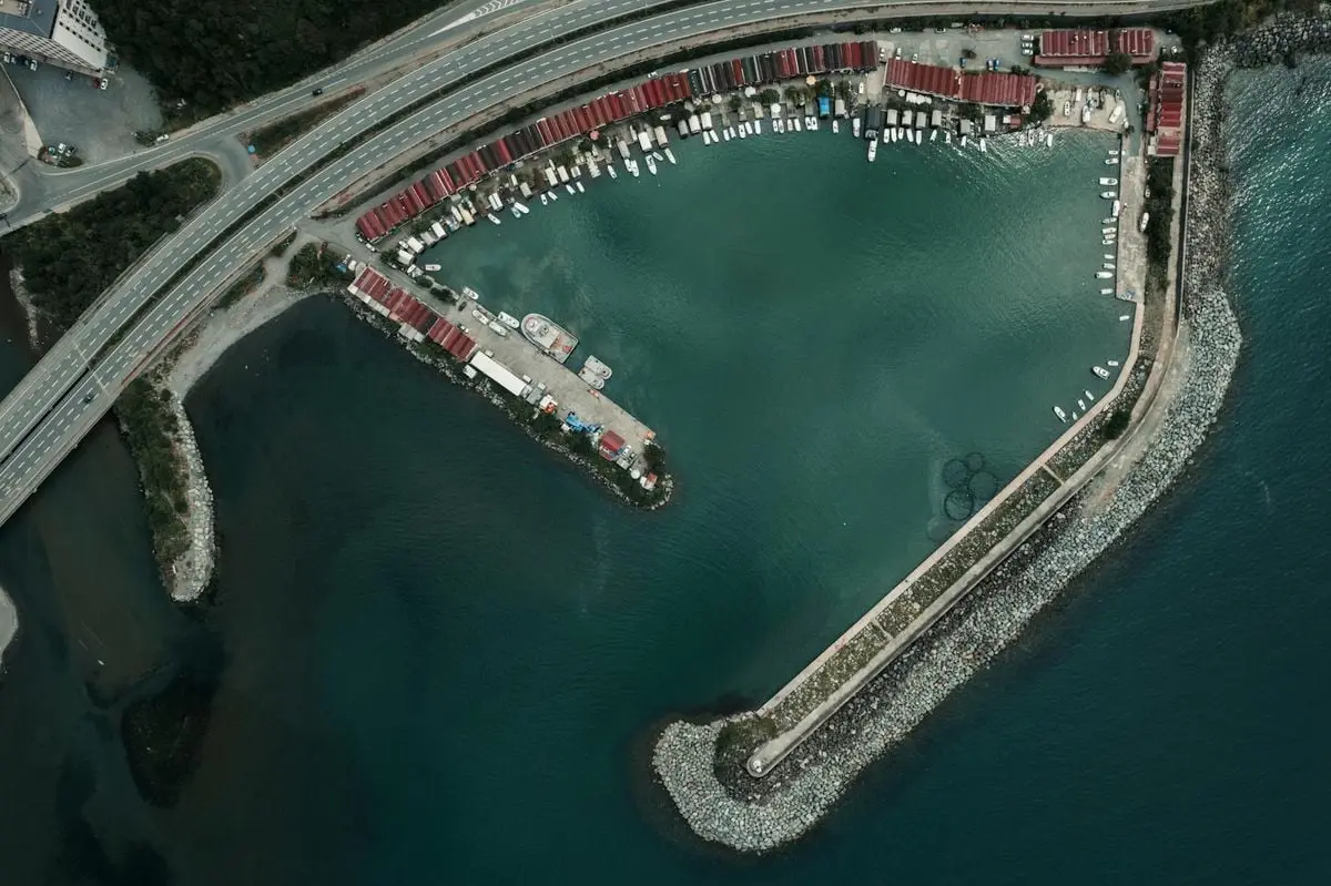 Aerial perspective of a marina, highway, and shoreline in Artvin, Türkiye.