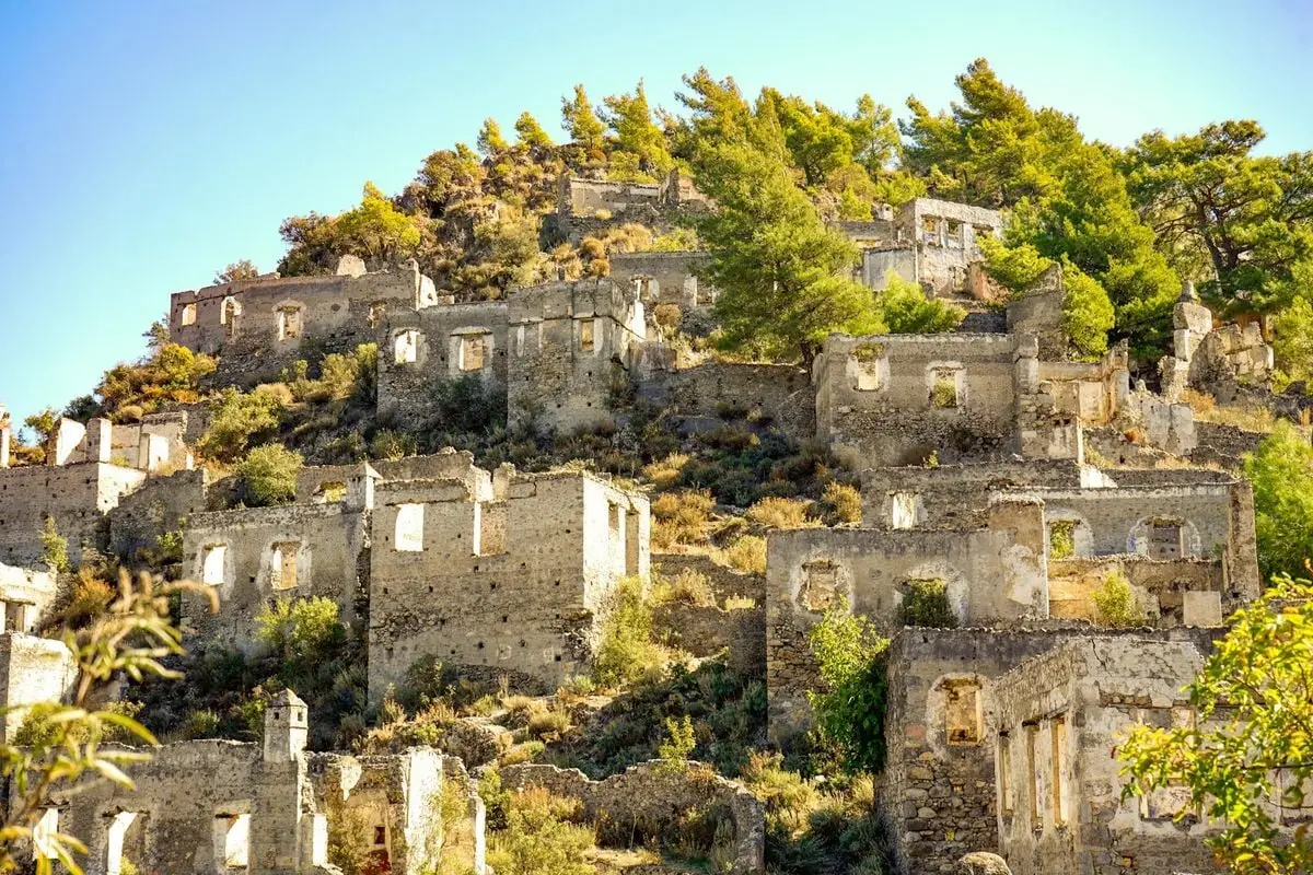 Discover the haunting beauty of Kayaköy ruins under a bright summer sun.