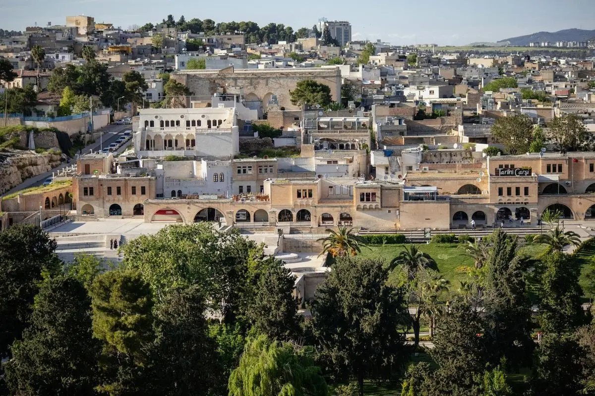 Explore the rich architectural heritage of Şanlıurfa with lush greenery in the foreground.
